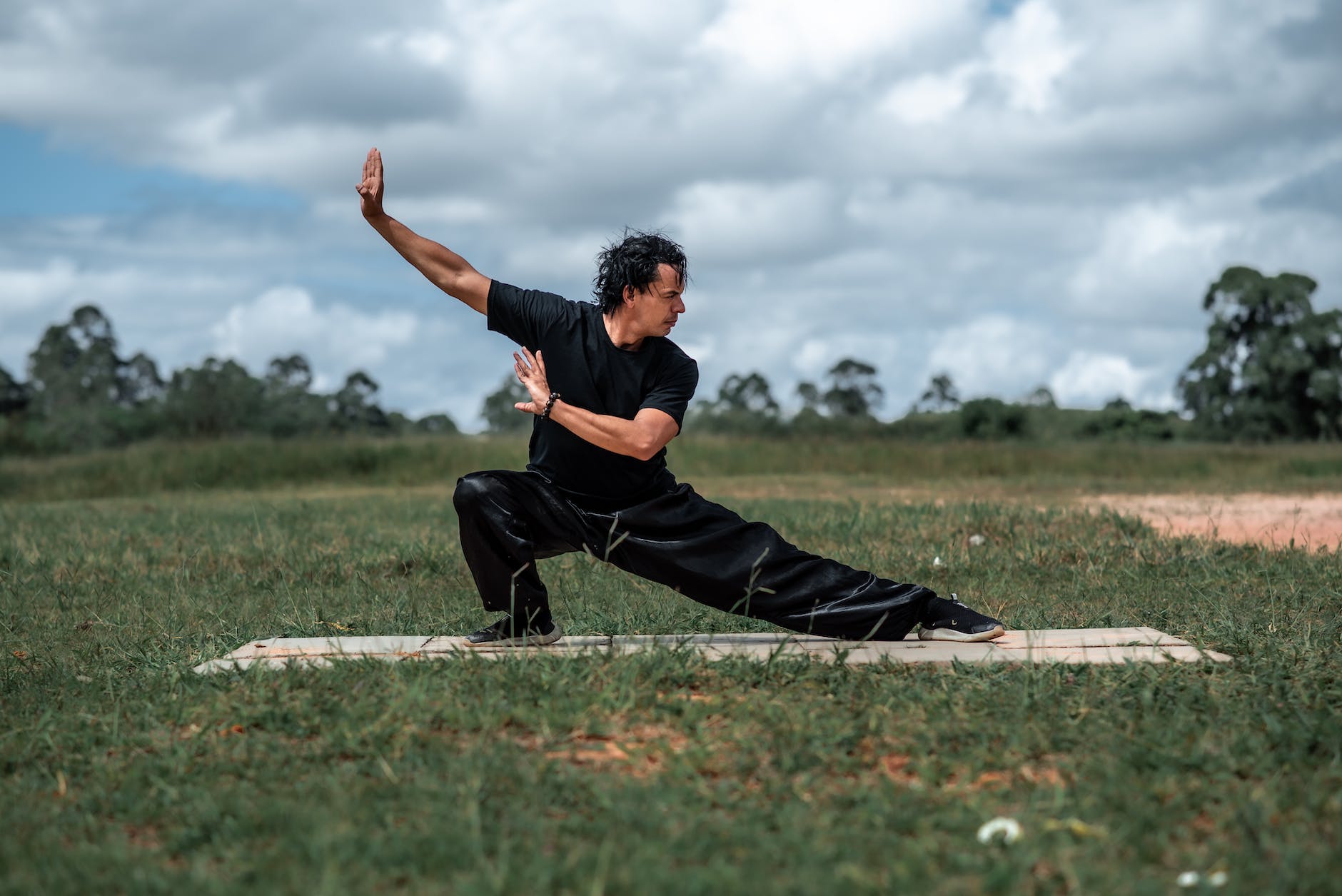 man in black outfit practicing tai chi