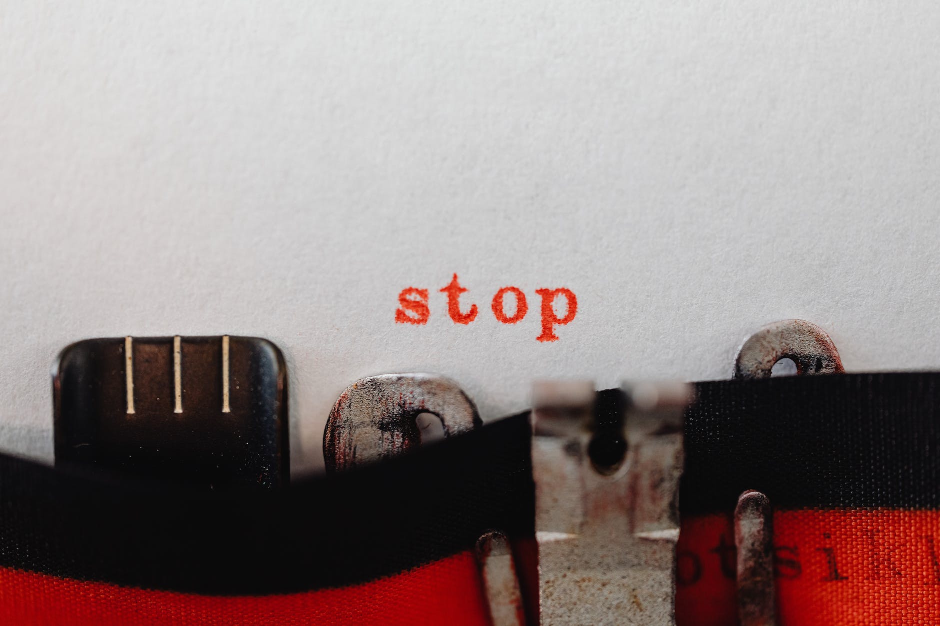 red stop word coming out of a typewriter